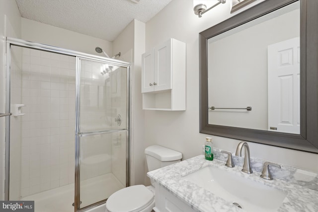 bathroom with walk in shower, vanity, a textured ceiling, and toilet