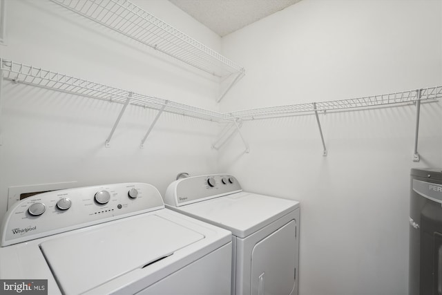 laundry area with electric water heater and washer and dryer