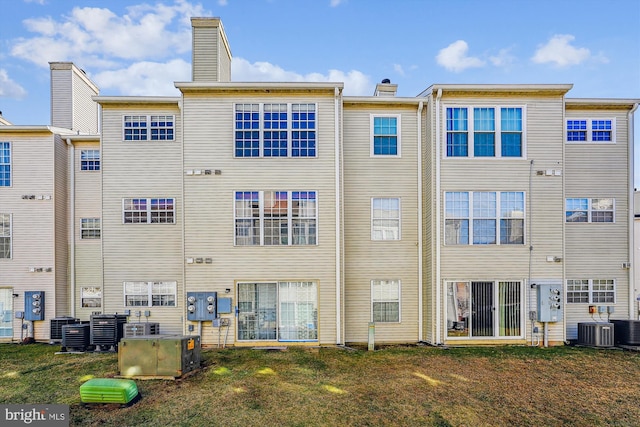 back of property featuring central AC and a lawn