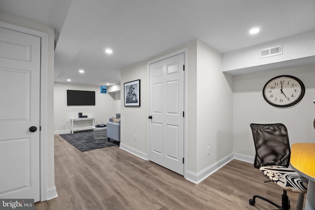 home office with light hardwood / wood-style flooring