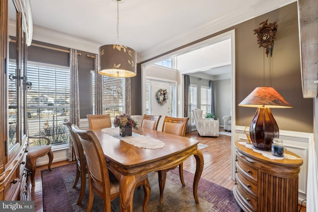 dining area with hardwood / wood-style floors and crown molding