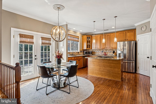 dining area with ornamental molding, sink, hardwood / wood-style floors, and a notable chandelier