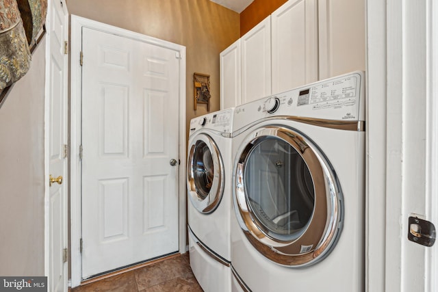 clothes washing area featuring cabinets and washing machine and clothes dryer