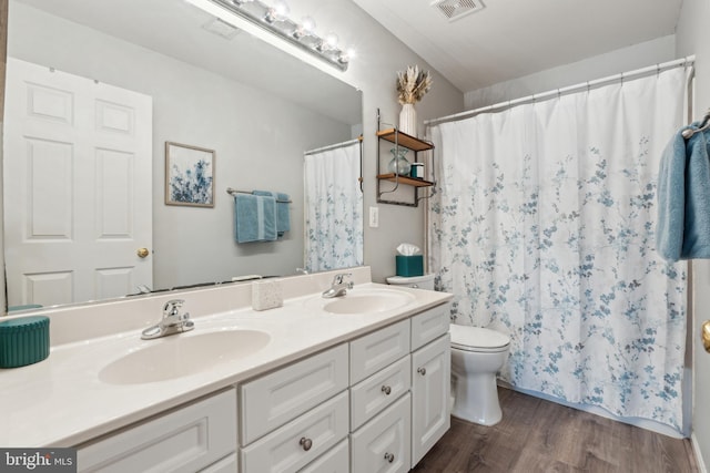 bathroom with vanity, toilet, and hardwood / wood-style floors