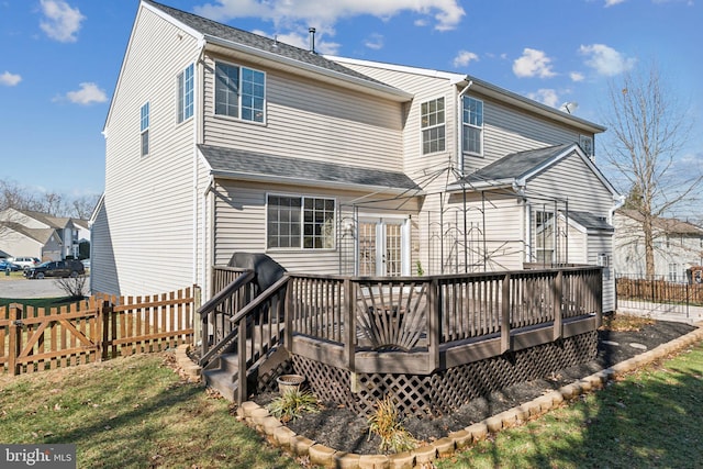 rear view of property featuring a wooden deck and a yard