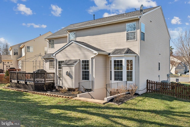 back of property featuring a deck and a lawn