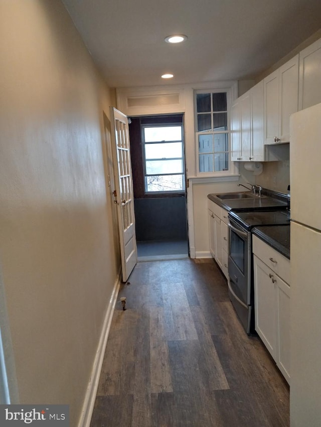 kitchen featuring sink, white cabinetry, dark hardwood / wood-style floors, white refrigerator, and stainless steel range with electric cooktop