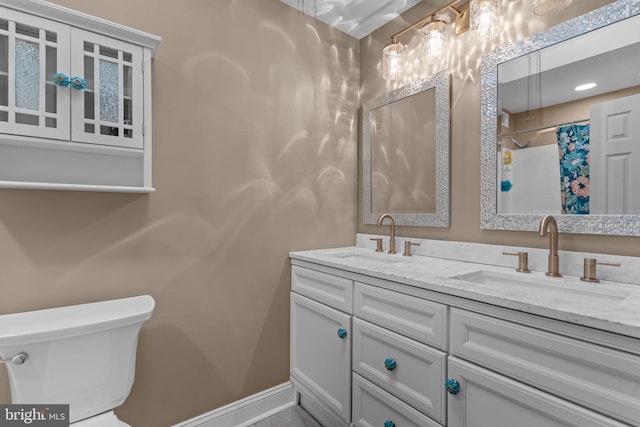 bathroom featuring toilet, vanity, and a shower with shower curtain