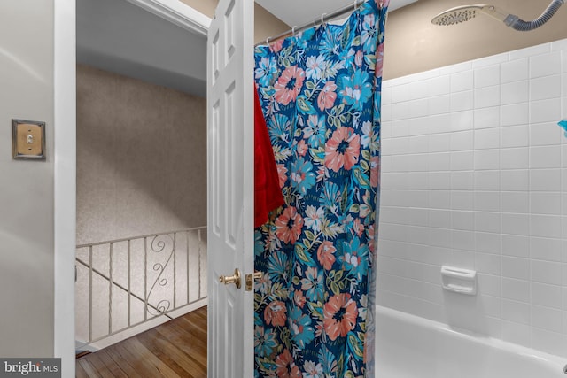 bathroom with hardwood / wood-style floors and shower / bath combination with curtain