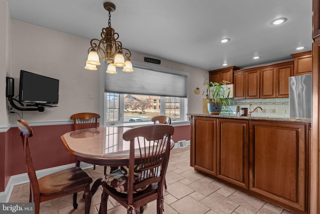 dining space featuring a chandelier and sink