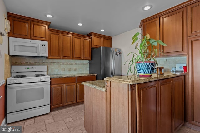 kitchen with white appliances, backsplash, and light stone counters