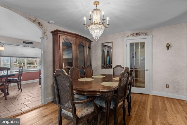 dining space with light wood-type flooring and a chandelier