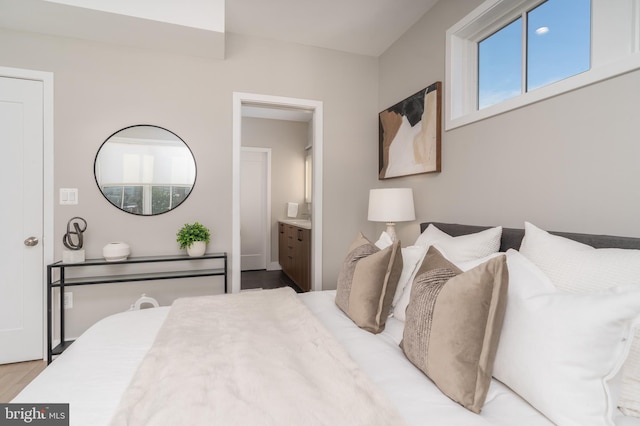 bedroom with hardwood / wood-style flooring and ensuite bathroom