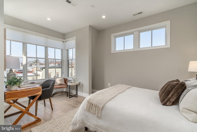 bedroom featuring multiple windows and light hardwood / wood-style flooring