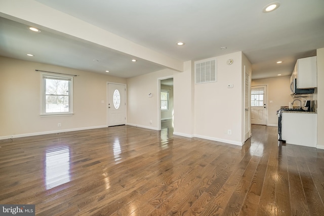 unfurnished living room with dark wood-type flooring