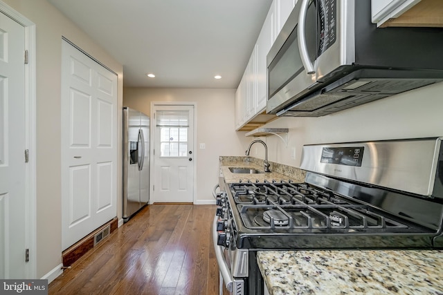 kitchen featuring white cabinetry, sink, light stone countertops, and appliances with stainless steel finishes