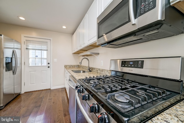 kitchen featuring sink, white cabinetry, stainless steel appliances, dark hardwood / wood-style floors, and light stone countertops