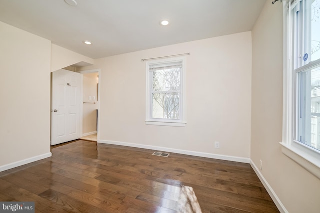 unfurnished room with dark wood-type flooring