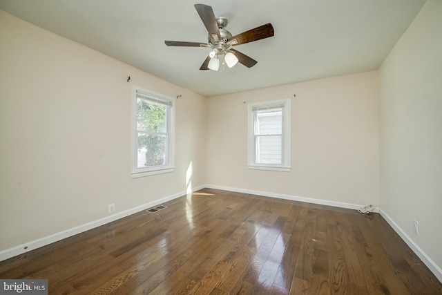 unfurnished room with dark hardwood / wood-style flooring, plenty of natural light, and ceiling fan