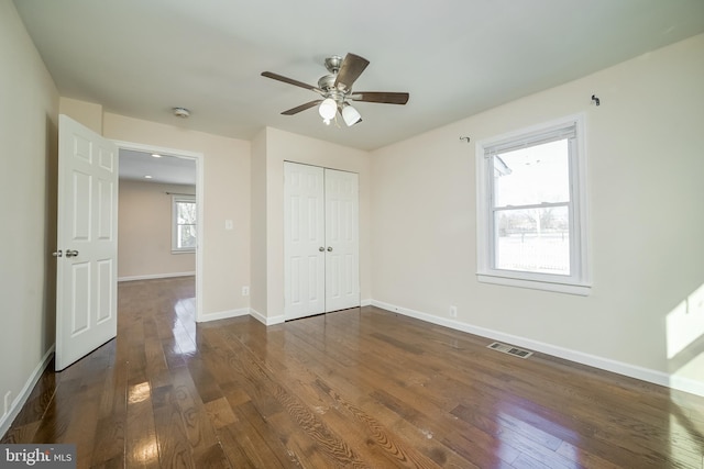 unfurnished bedroom featuring a closet, dark hardwood / wood-style floors, and ceiling fan