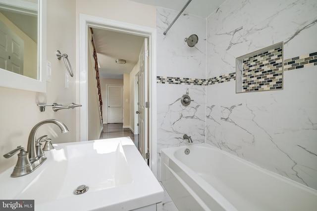 bathroom with tiled shower / bath combo and sink