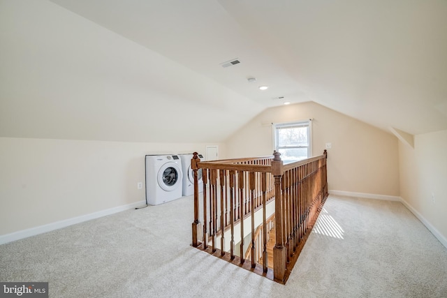 bonus room featuring lofted ceiling, washer / dryer, and light colored carpet