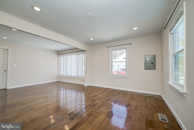 empty room featuring electric panel and dark hardwood / wood-style floors