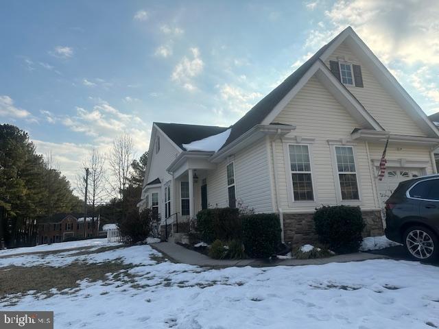 snow covered property with a garage