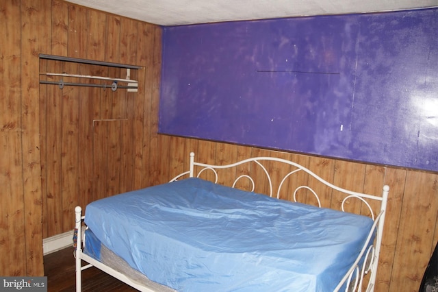 bedroom featuring hardwood / wood-style flooring and wood walls