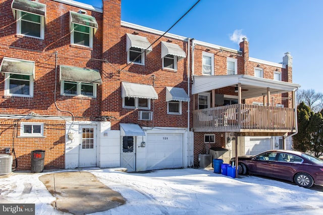 back of property featuring a garage and central AC unit