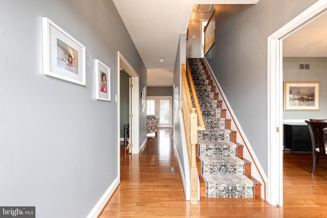 staircase with hardwood / wood-style floors