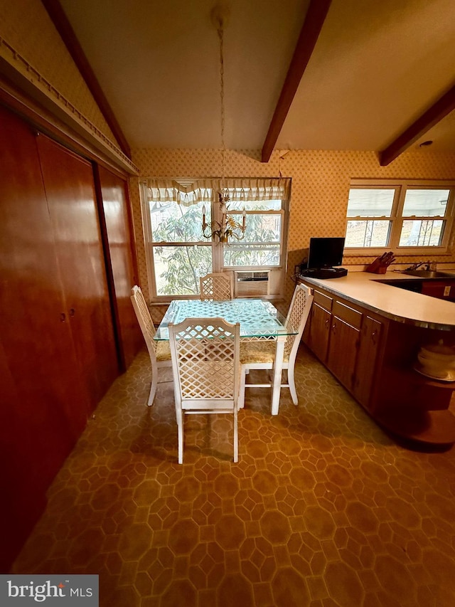 dining area featuring wallpapered walls and lofted ceiling with beams