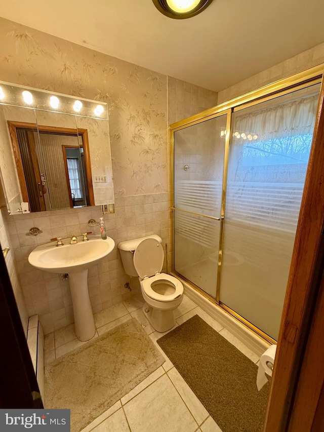 bathroom with a wainscoted wall, a shower stall, wallpapered walls, and tile walls