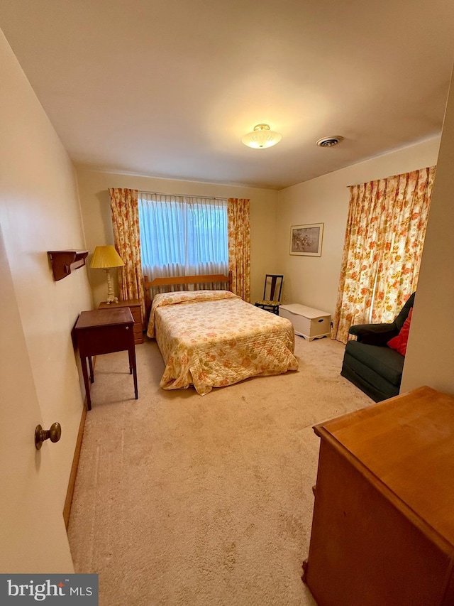 carpeted bedroom featuring visible vents