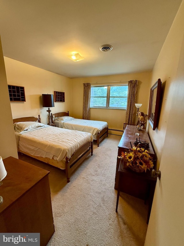 carpeted bedroom with visible vents and baseboard heating