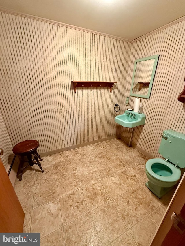 bathroom featuring tile patterned flooring, toilet, baseboards, and a sink