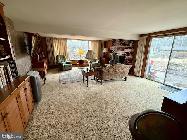 living room with a wealth of natural light, light colored carpet, and a brick fireplace