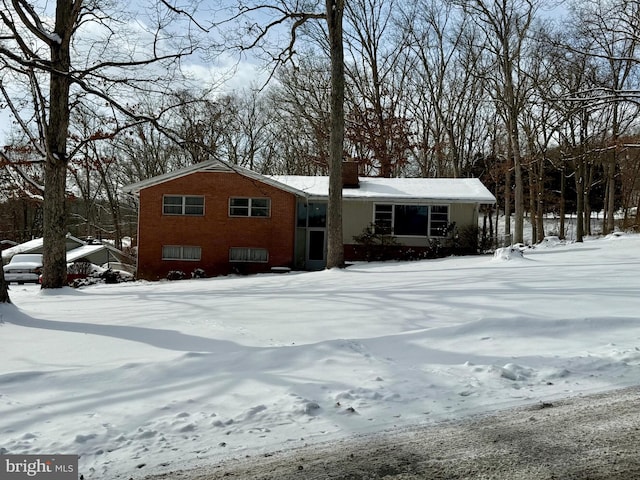 view of front of house featuring brick siding and a chimney