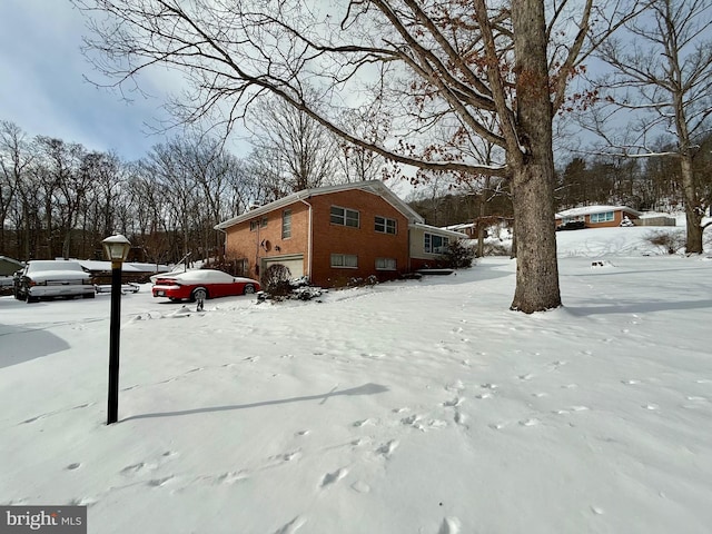 snowy yard featuring an attached garage