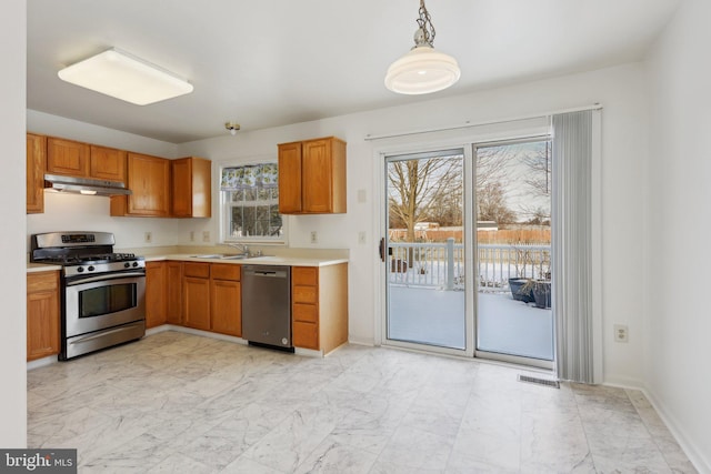 kitchen with pendant lighting, stainless steel appliances, and sink