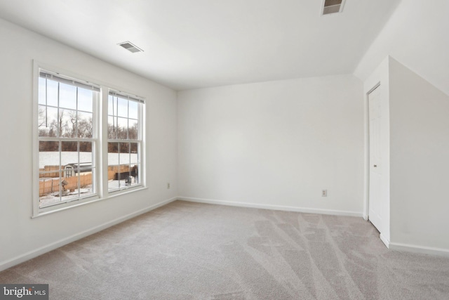 unfurnished room with light carpet and lofted ceiling