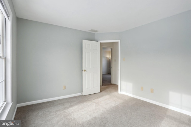 carpeted empty room with a healthy amount of sunlight