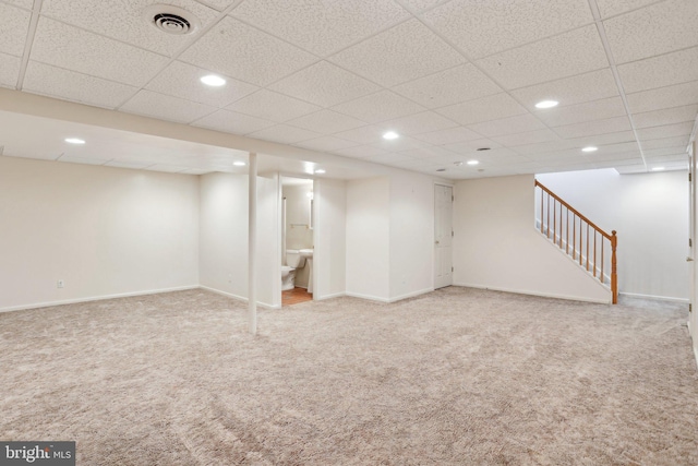 basement featuring a paneled ceiling and carpet floors