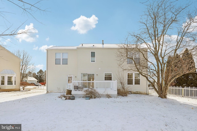 snow covered house with a wooden deck