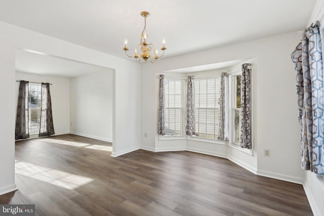 unfurnished dining area featuring dark hardwood / wood-style flooring and an inviting chandelier