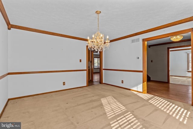 carpeted spare room with a notable chandelier and ornamental molding