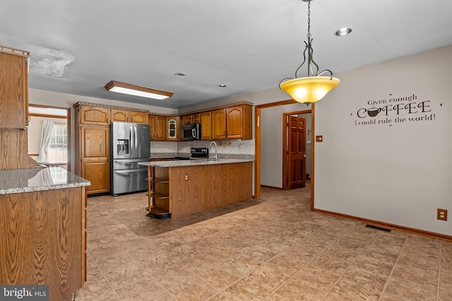 kitchen featuring appliances with stainless steel finishes, decorative light fixtures, sink, backsplash, and kitchen peninsula