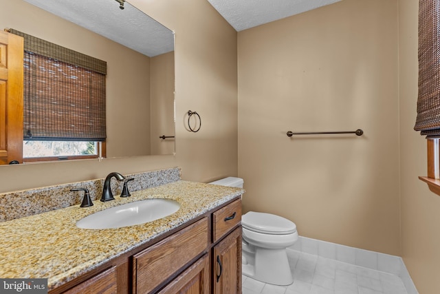 bathroom featuring vanity, tile patterned floors, a textured ceiling, and toilet