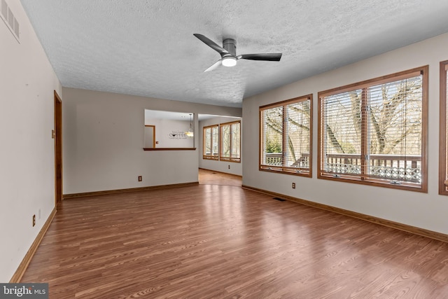 unfurnished living room with hardwood / wood-style flooring, ceiling fan, and a textured ceiling