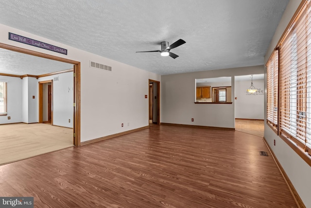 unfurnished living room with hardwood / wood-style flooring, ceiling fan, and a textured ceiling